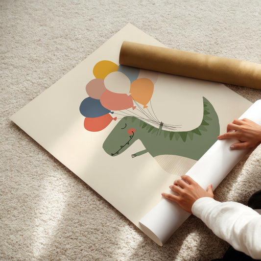 A large wall mural or poster featuring a green dinosaur holding colorful balloons, partially unrolled on a beige carpet with a person's hands visible rolling up the bottom edge. A brown cardboard mailing tube lies nearby.