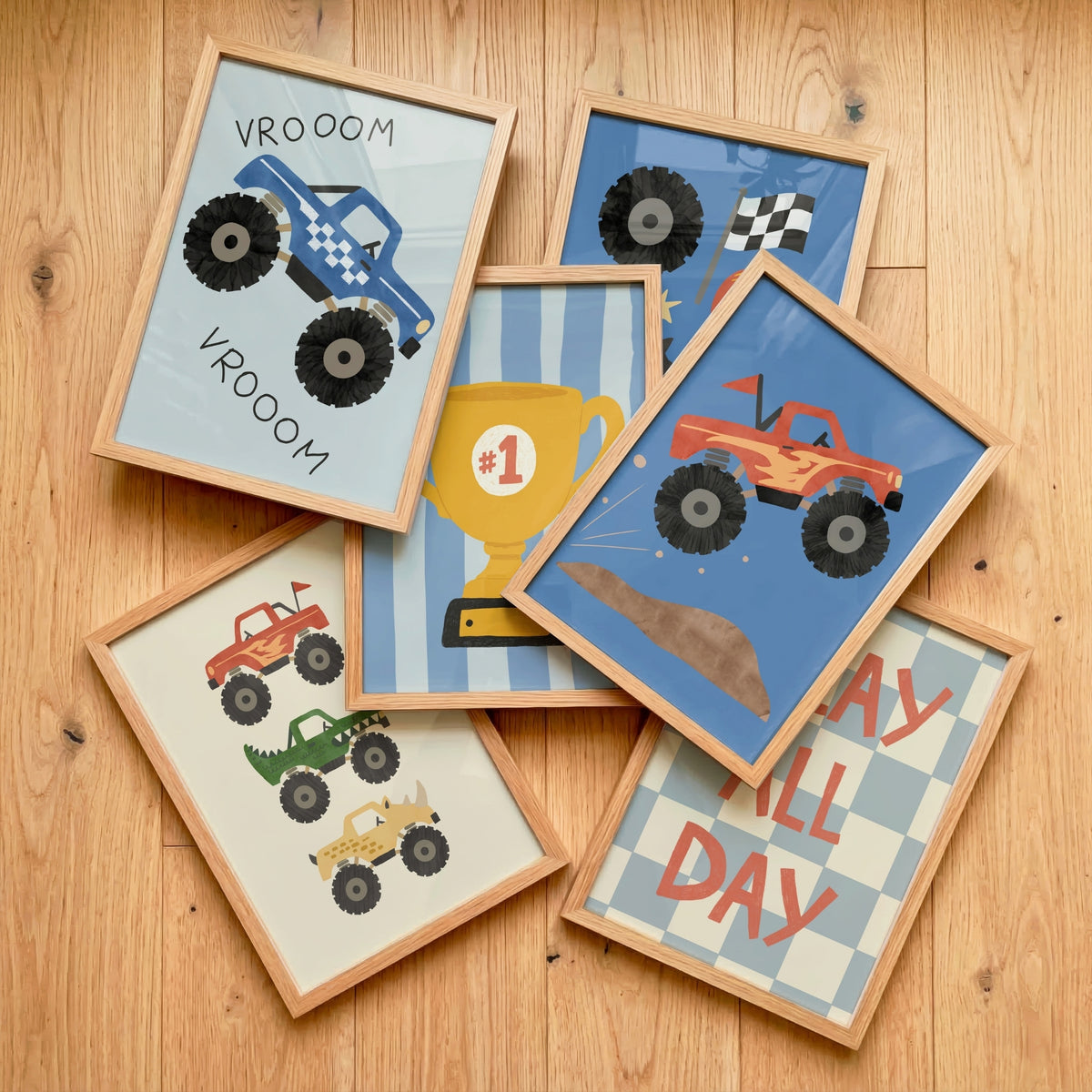 Flat lay of framed monster truck kids prints with Vrooom truck, number one trophy, jumping truck and Play All Day poster