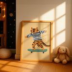 A framed children's art print featuring a cartoon tiger in a navy and white striped shirt balancing on a teal skateboard, leaning against a wall in a sunlit nursery next to a stuffed bunny.