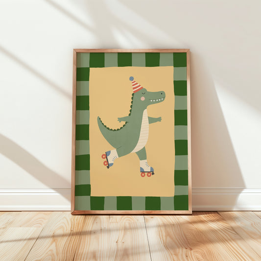 A framed children's art print featuring a green cartoon alligator wearing a party hat and roller skates, set against a cream background with a green plaid border. The framed print is leaning against a white wall on a light wood floor.