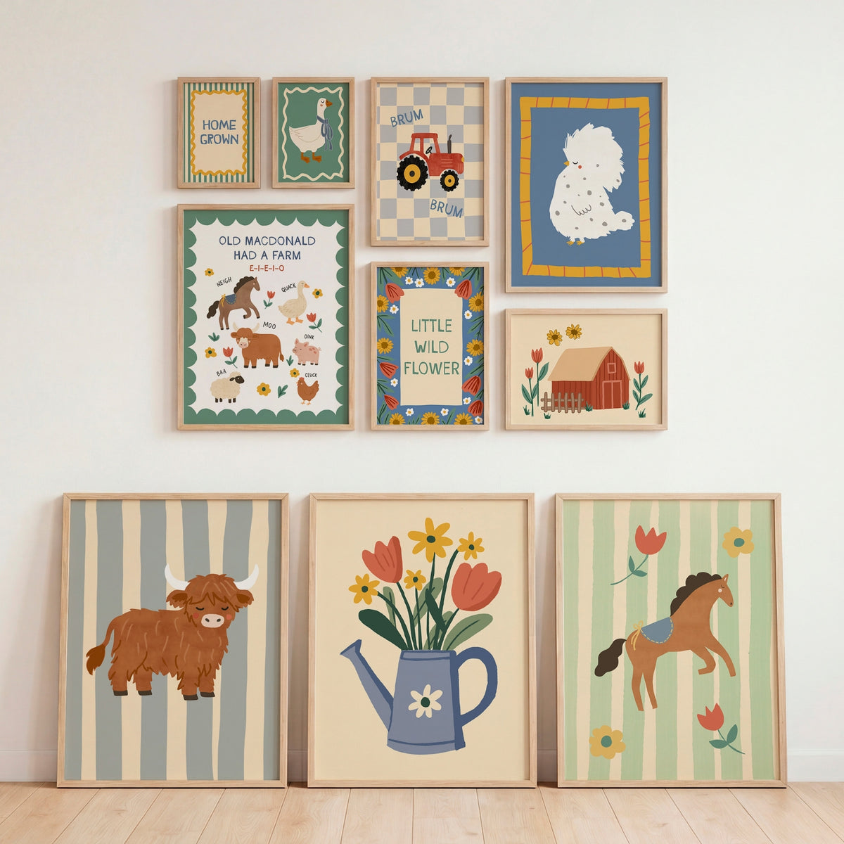 A set of nine framed country-themed art prints arranged on a white wall above a light wood floor, including illustrations of a cow, flowers in a watering can, a horse, a tractor, a sheep, and farm animals.