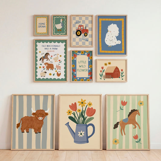 A set of nine framed country-themed art prints arranged on a white wall above a light wood floor, including illustrations of a cow, flowers in a watering can, a horse, a tractor, a sheep, and farm animals.