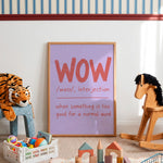 A framed nursery art print leaning against a white wall in a child's playroom. The print features a light purple background with the word 'WOW' in large coral-red letters and a definition below.