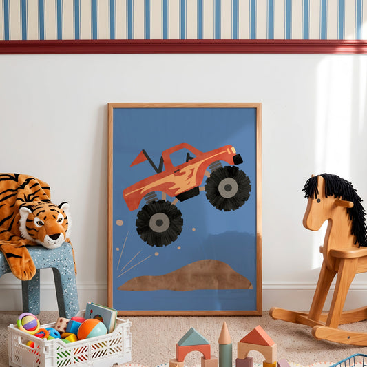 A framed children's art print featuring a red and orange monster truck jumping over a brown hill on a blue background, styled in a nursery or playroom with a tiger plush, wooden rocking horse, and toy boxes.