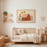 A framed art print featuring a red barn, yellow flowers, and red tulips, displayed on a cream wall above a wooden children's daybed in a styled nursery room.