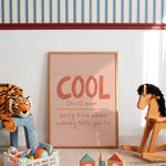 Framed cool definition print leaning against playroom wall beside rocking horse, tiger plush and toy blocks