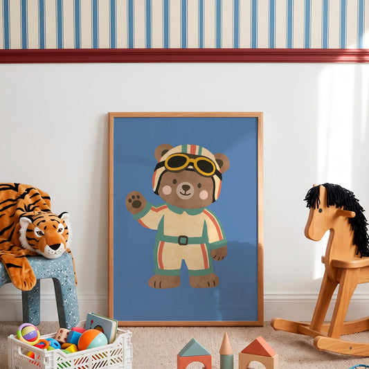 Framed racing bear print leaning against playroom wall beside rocking horse, tiger plush and toy blocks