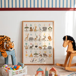 A framed children's alphabet animal poster displayed on a wall in a styled nursery or playroom. The poster shows uppercase letters A through Y with corresponding illustrated animals such as elephant, giraffe, lion, and sun.