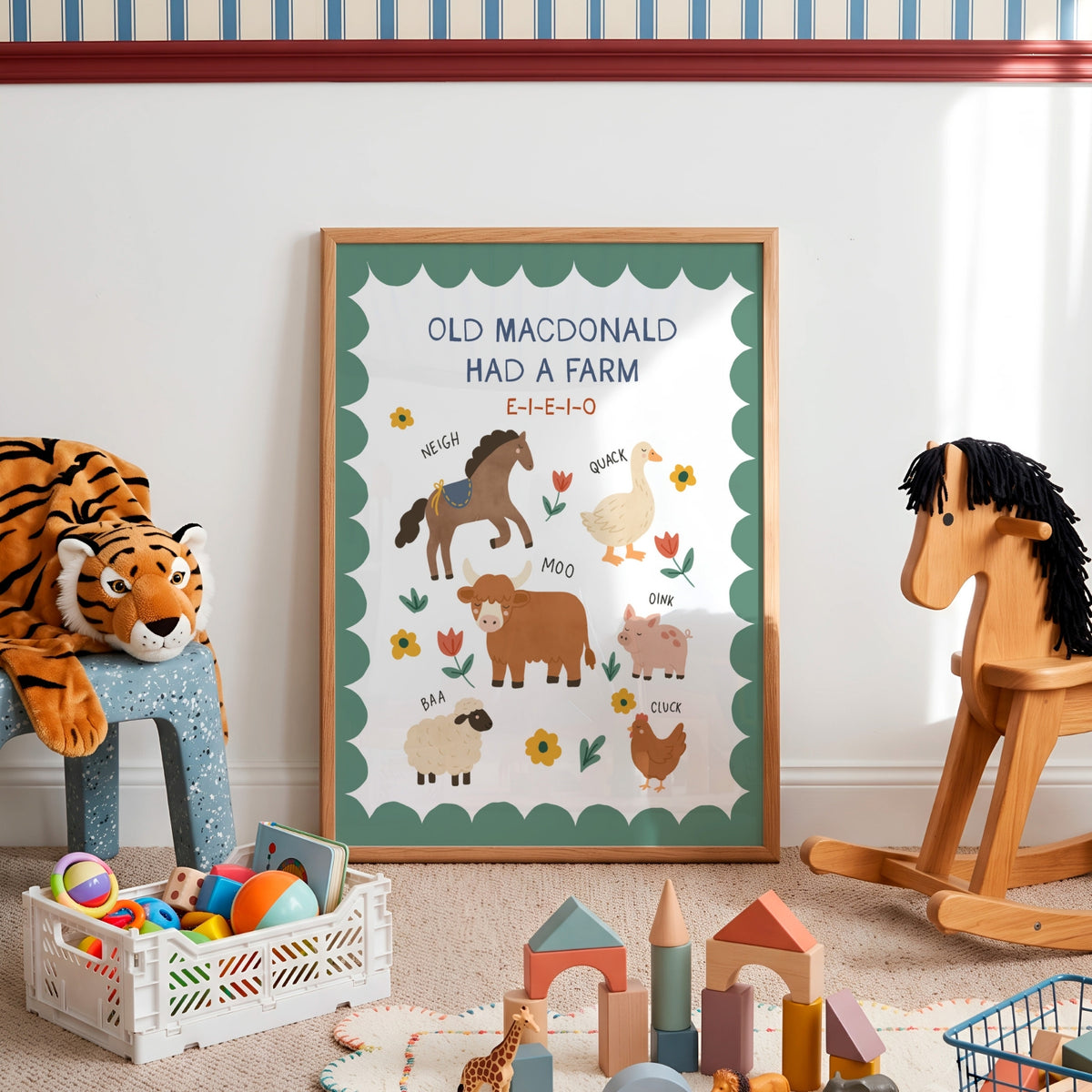 A framed children's educational poster reading 'OLD MACDONALD HAD A FARM' with illustrated farm animals and flowers, displayed in a styled nursery or playroom setting with toys around it.