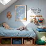 A styled children's bedroom corner with a wooden bed frame under a slanted ceiling, dressed in light blue bedding. A plush elephant and a beige pillow rest on the bed.