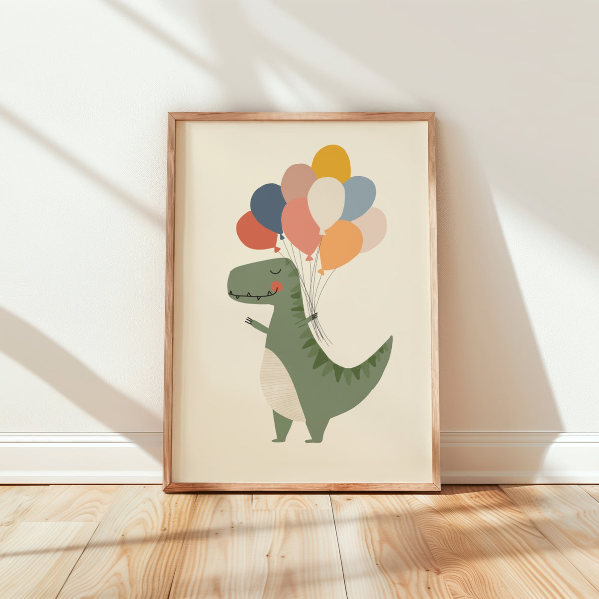 A framed children's art print featuring a cute green dinosaur holding a bunch of colorful balloons, leaning against a white wall on a light wood floor.