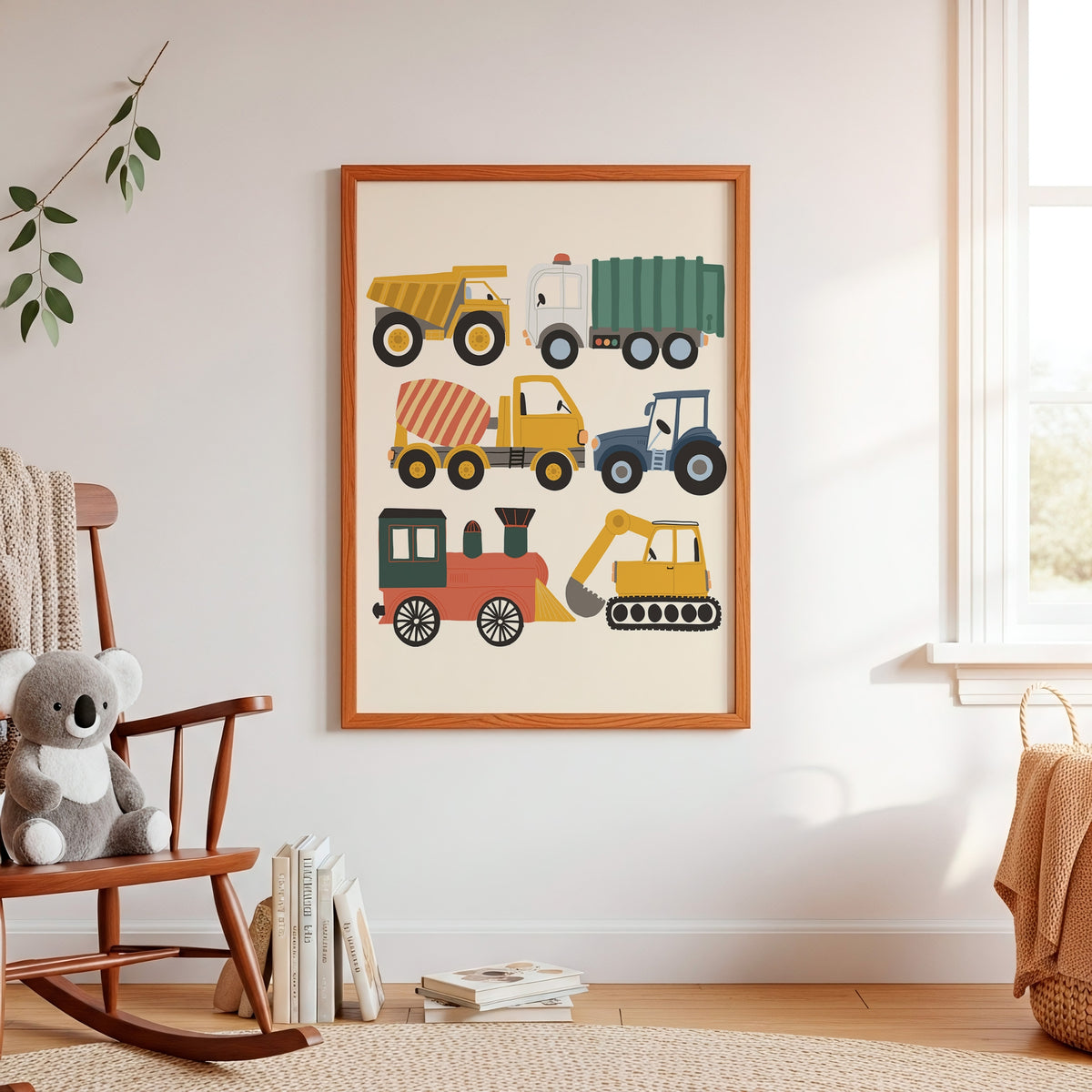 A framed children's wall art print featuring colorful cartoon construction vehicles, hanging on a white wall in a styled nursery with a wooden rocking chair, books, and a window.