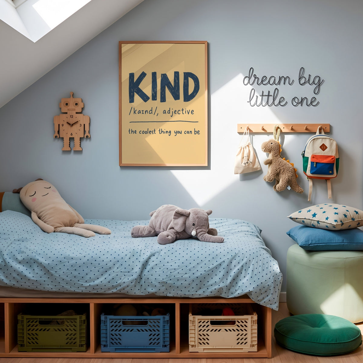 A styled children's bedroom corner with a wooden bed frame, light blue polka-dot bedding, plush toys, wall decor including a framed 'KIND' print and 'dream big little one' sign, storage bins, pillows, and a green ottoman under a skylight.