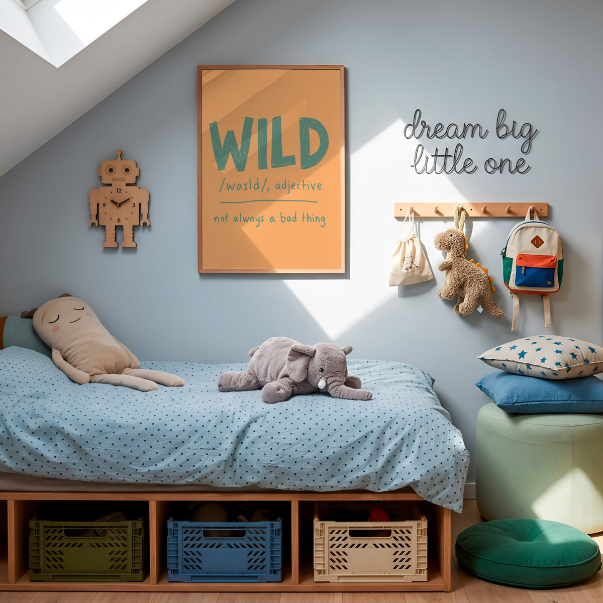 A styled children's bedroom corner with a low wooden bed, light blue bedding, plush toys, wall art reading 'WILD' and 'dream big little one', storage bins underneath, and a mint ottoman with star pillows.