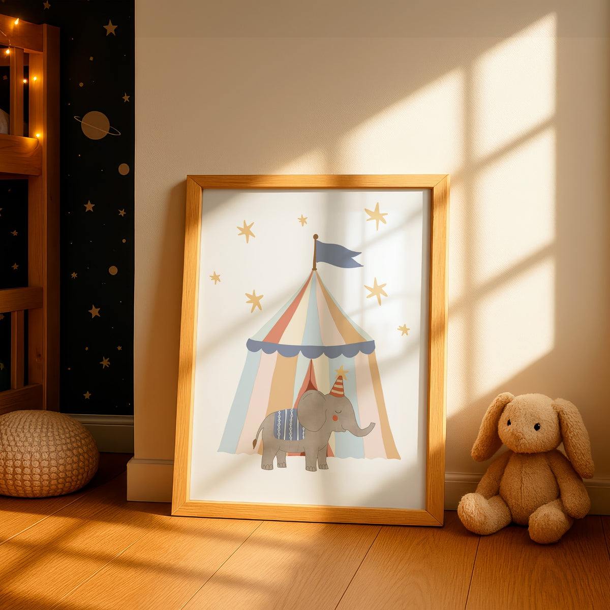 A framed children's art print featuring a circus tent with a gray elephant under stars, leaning against a wall in a sunlit nursery next to a stuffed bunny.
