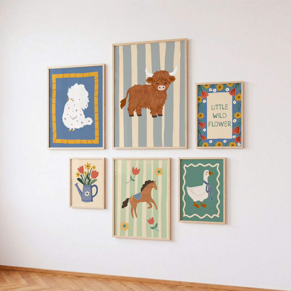 Six framed whimsical art prints arranged in a gallery wall on a white wall above a light wood floor. The prints feature a white poodle on blue, a brown Highland cow on gray stripes, a blue watering can with tulips, a brown horse, and a white goose.