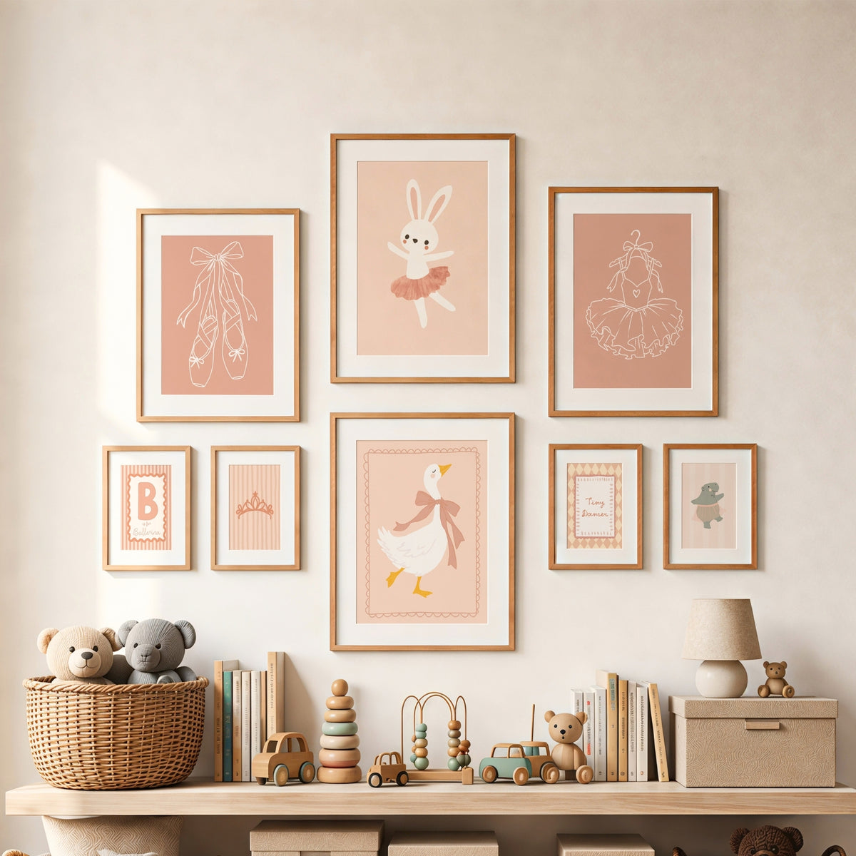 A styled nursery wall display featuring eight framed pastel art prints with ballet-themed illustrations, including a bunny, ballerina tutus, duck, and decorative monograms, arranged above a wooden shelf with toys and books.