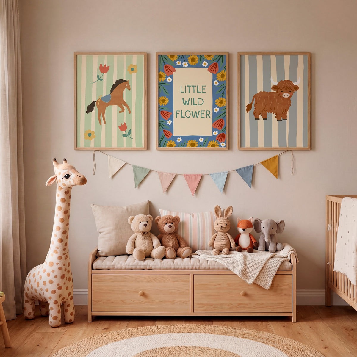 A styled children's nursery interior with three framed animal-themed wall prints above a wooden storage bench. The prints show a horse, a flower-bordered sign reading 'LITTLE WILD FLOWER,' and a cow.