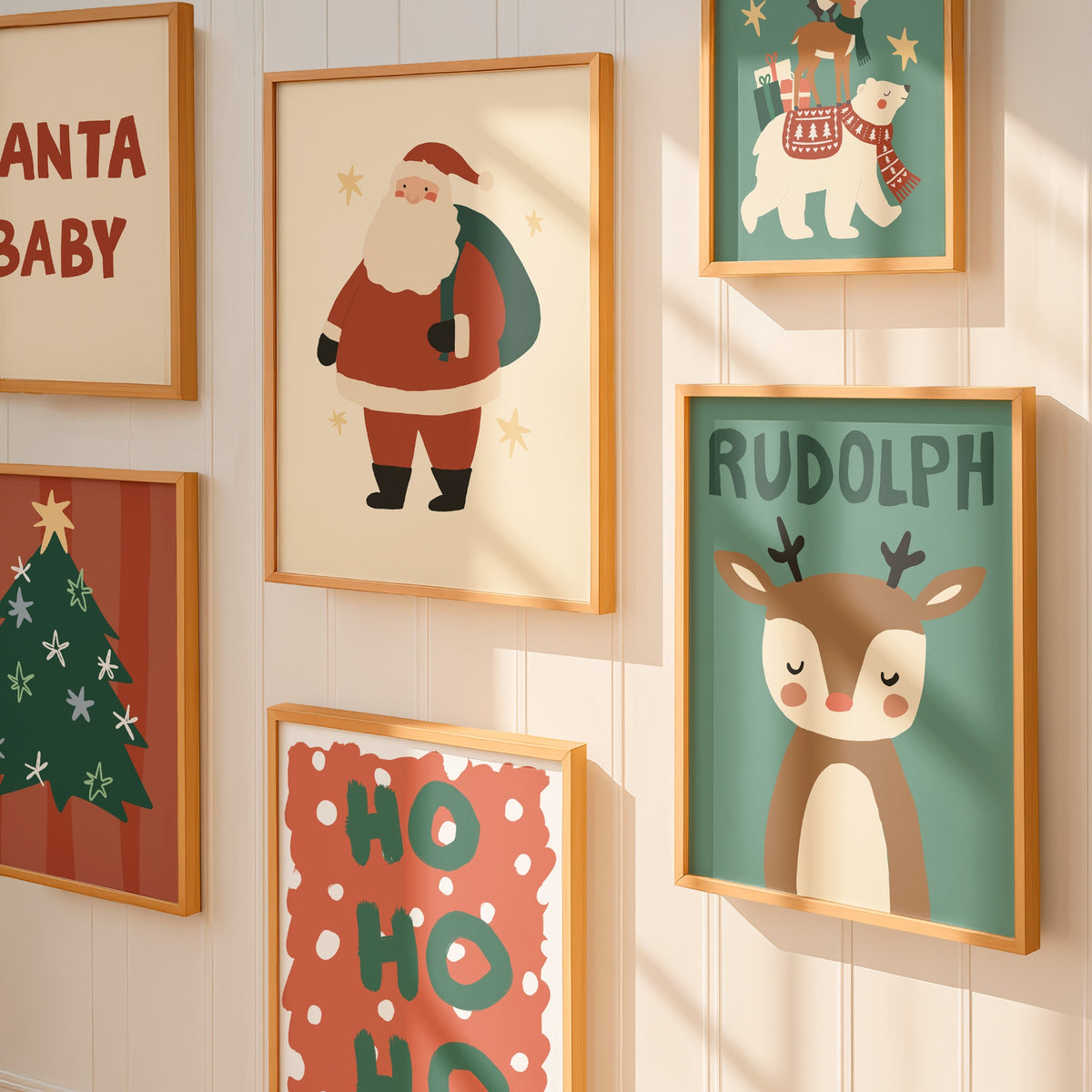 A set of six framed Christmas-themed art prints displayed on a light beige paneled wall. The prints feature festive illustrations including Santa Claus, Rudolph the Red-Nosed Reindeer, a Christmas tree, a polar bear, and 'HO HO HO' text, each in a light wood frame.