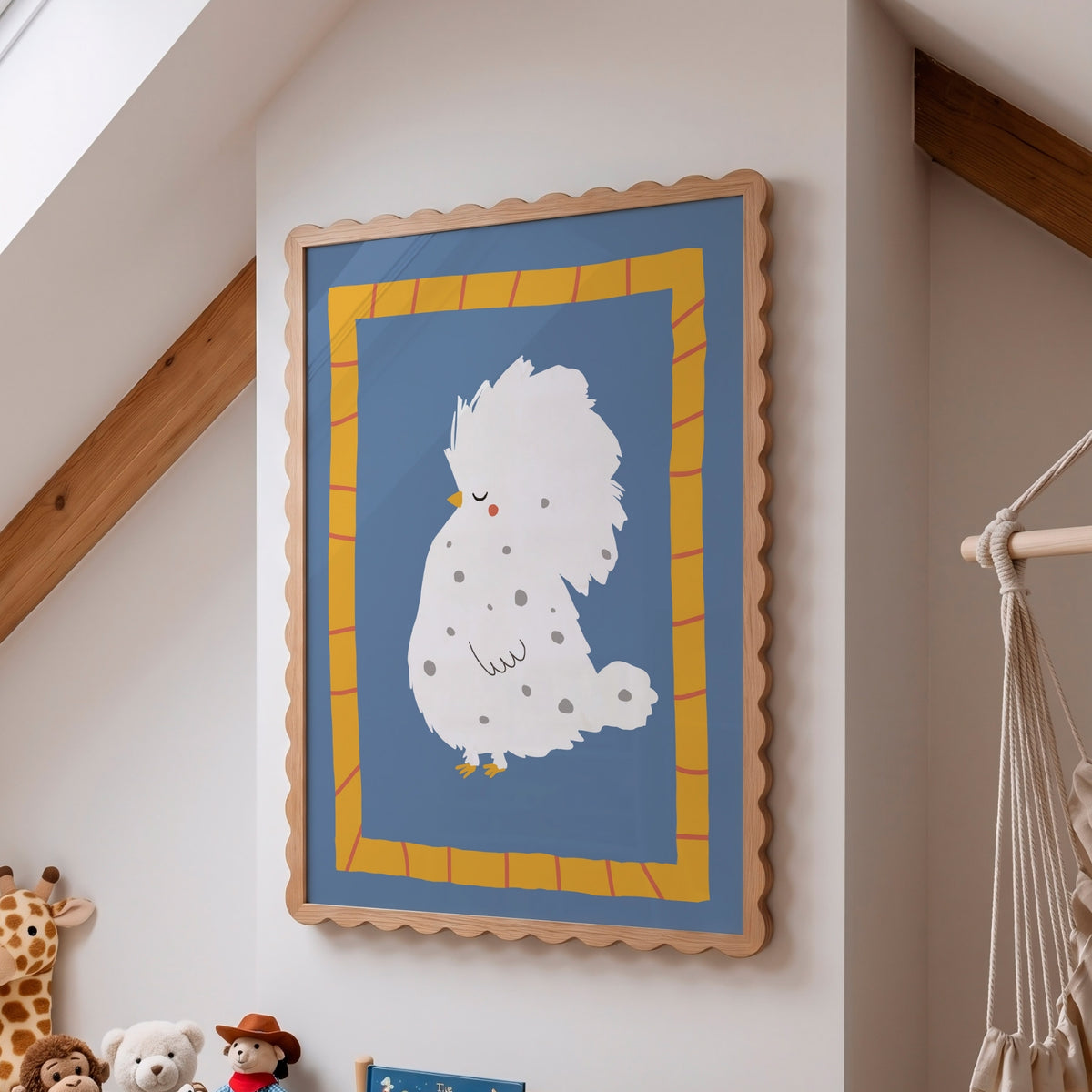 A framed wall art print featuring a white fluffy bird illustration on a blue background with a yellow patterned border, hung on a beige wall in a child's room with wooden beams and toys visible.