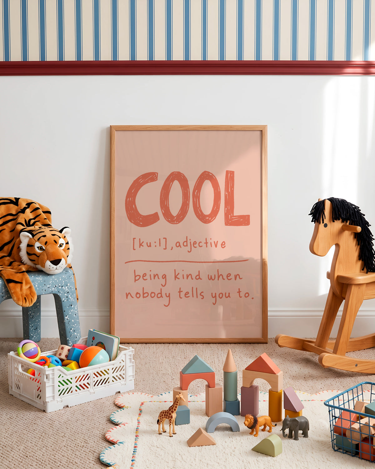 A framed art print with the word 'COOL' and a dictionary definition, styled in a child's playroom with toys, a rocking horse, and a stuffed tiger.