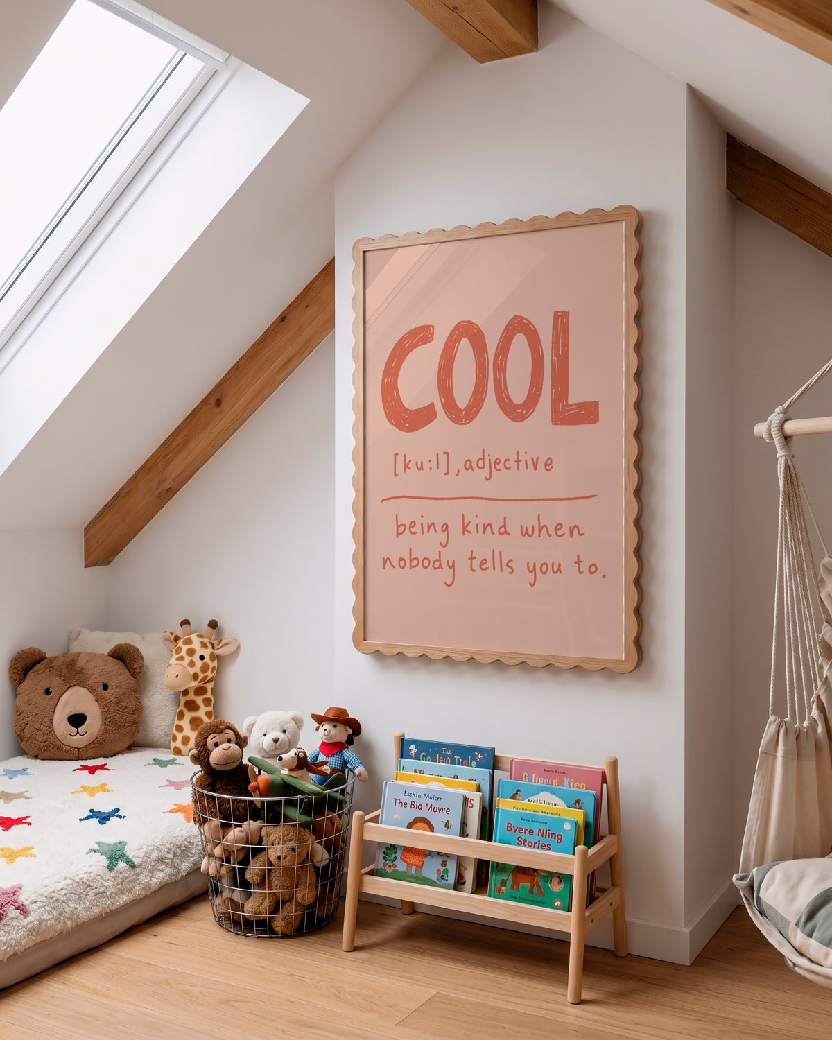 A styled children's bedroom corner with a slanted ceiling, skylight, wooden beams, a bed with stuffed toys, a small wooden book rack, and a framed wall print featuring the word 'COOL' in orange-red lettering on a pale pink background.