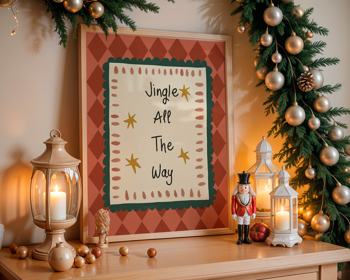 A framed Christmas art print with the text 'Jingle All The Way' displayed on a wooden mantel, surrounded by holiday decorations including a lit lantern, nutcracker, garland, and ornaments.