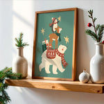 A framed art print featuring a whimsical Christmas scene with polar bears and a deer, styled on a wooden shelf with white ceramic vases and greenery against a white wall.