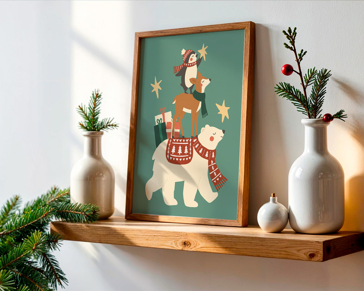 A framed art print featuring a whimsical Christmas scene with polar bears and a deer, styled on a wooden shelf with white ceramic vases and greenery against a white wall.
