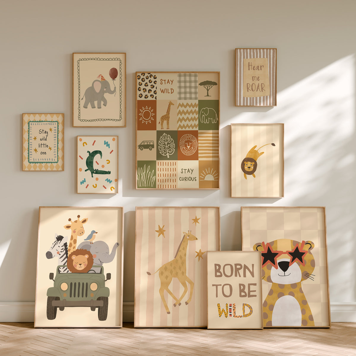A set of framed children's wall art prints arranged on a wall and floor in a styled nursery setting. The prints feature safari-themed illustrations including an elephant, lion, giraffe, cheetah, zebra, sun, trees, and text phrases like 'Stay and see,' 'Stay curious,' 'Peace and love,' and 'BORN TO BE WILD.