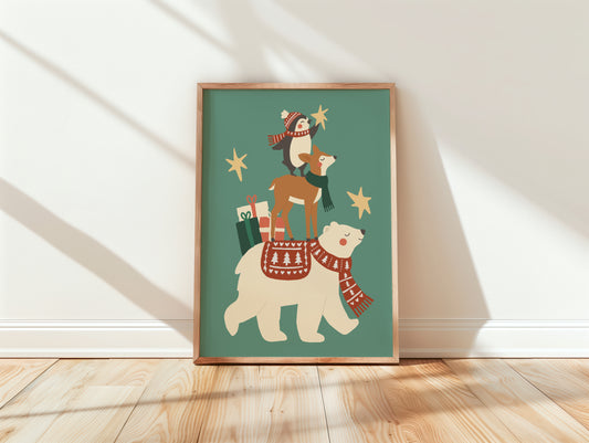 A framed art print leaning against a white wall on a light wood floor. The print shows a whimsical illustration of a polar bear wearing a red patterned scarf and carrying a deer on its back, with a penguin, stars, and gift bags on a muted teal background.